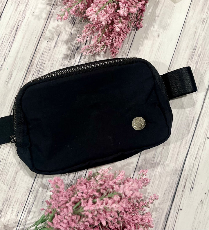 a black bag sitting on top of a white wooden floor