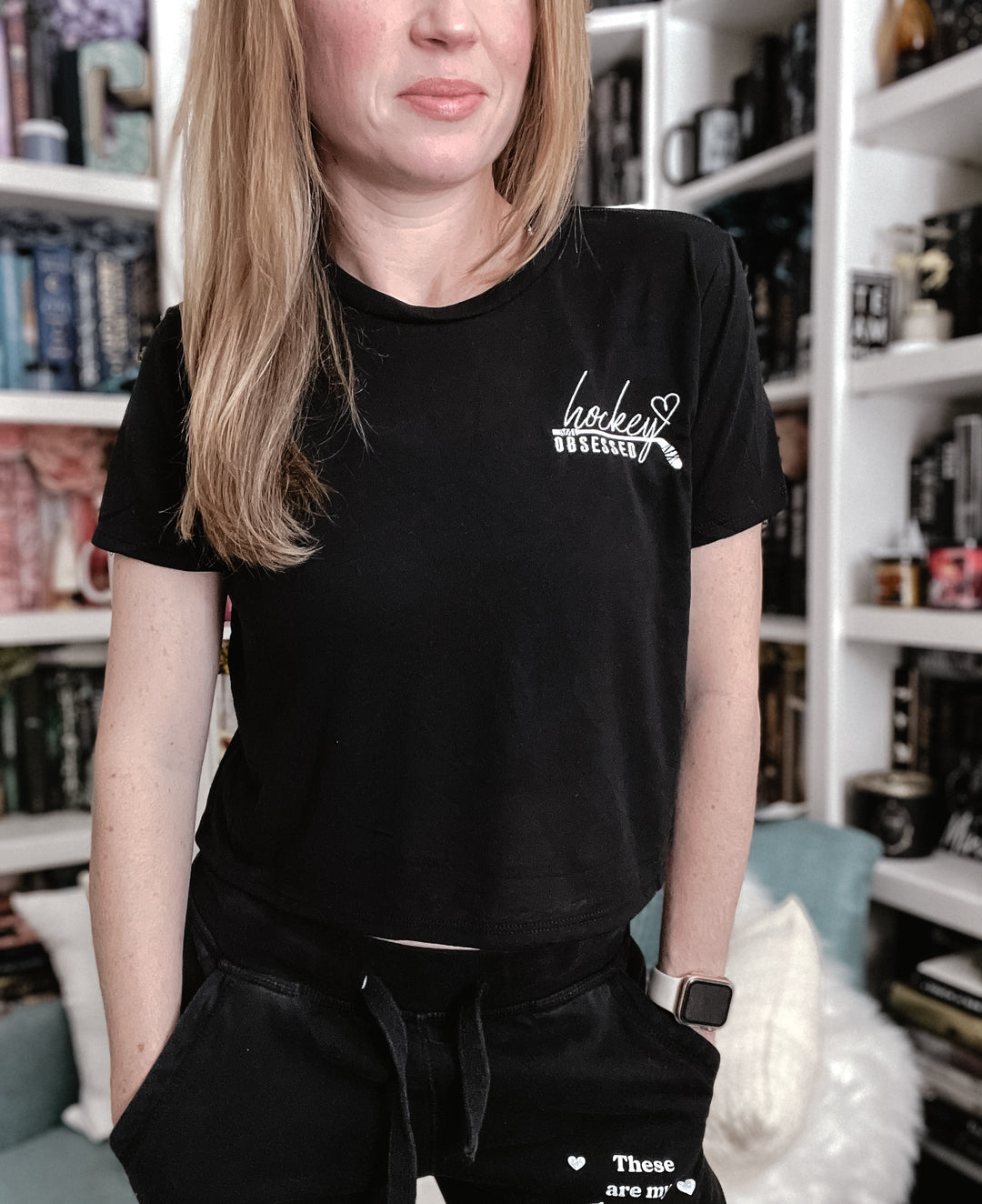 a woman standing in front of a book shelf