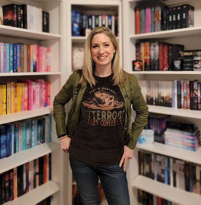 a woman standing in front of a book shelf