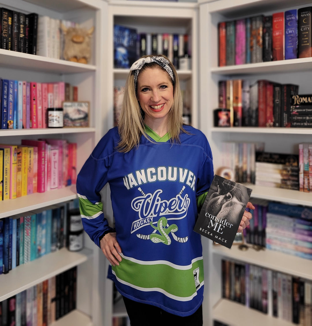 a woman standing in front of a bookshelf holding a book