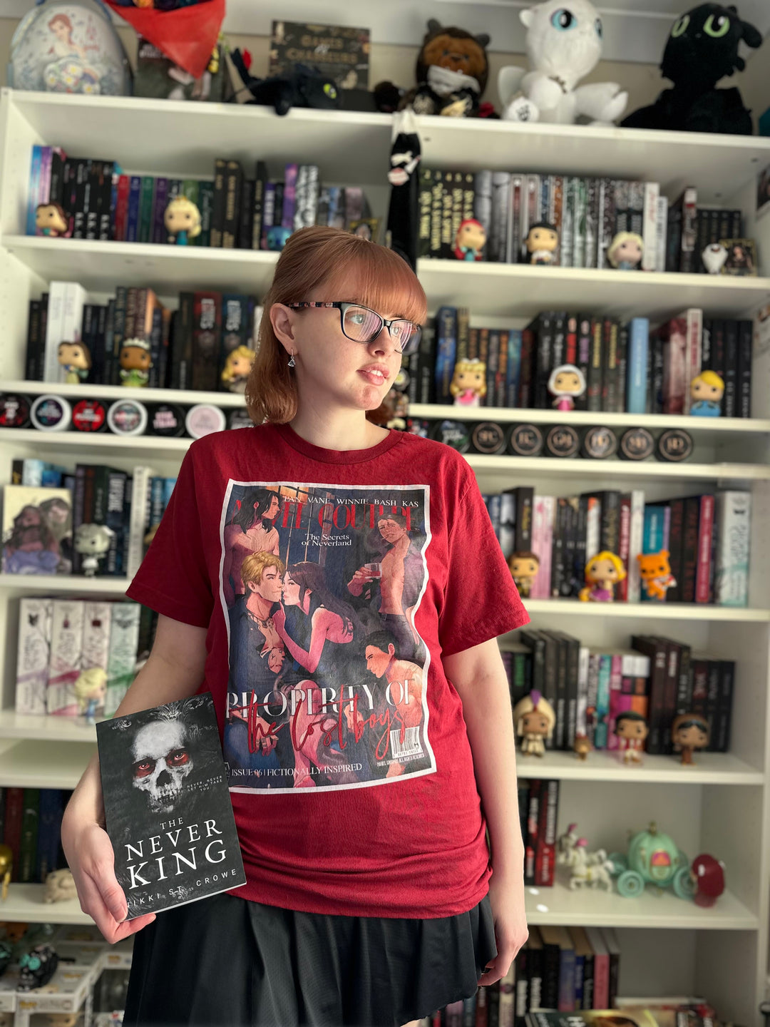 a girl standing in front of a bookshelf holding a book