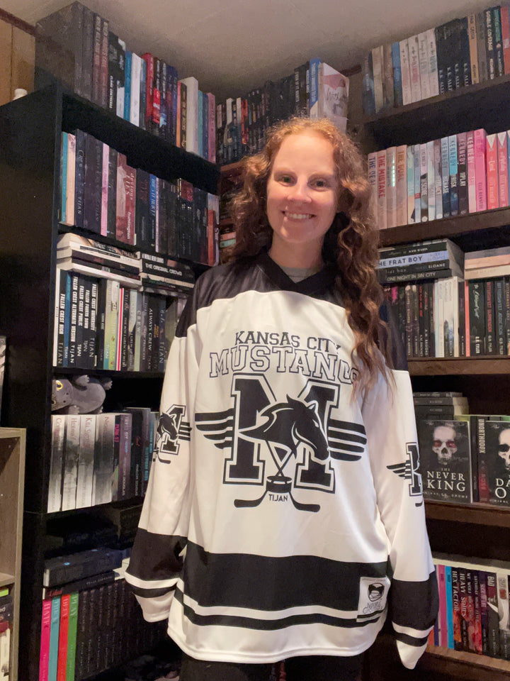 a woman standing in front of a large amount of dvds