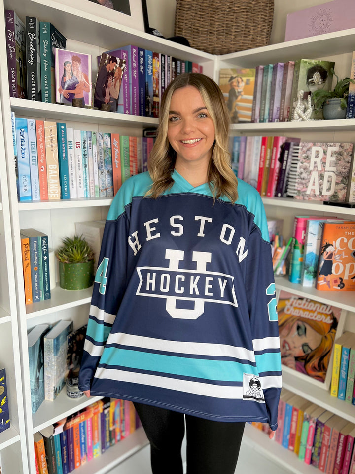 a woman standing in front of a book shelf holding a hockey jersey
