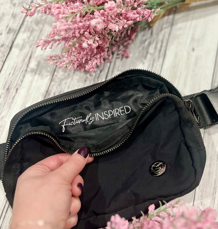 a person holding a black purse with a pink flower in the background