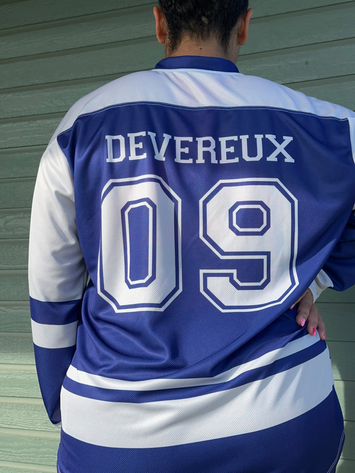 a man in a blue and white jersey holding onto a bag