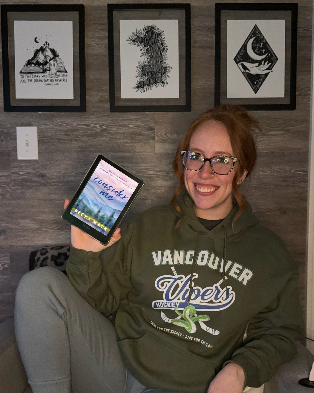 a woman sitting on a couch holding a tablet