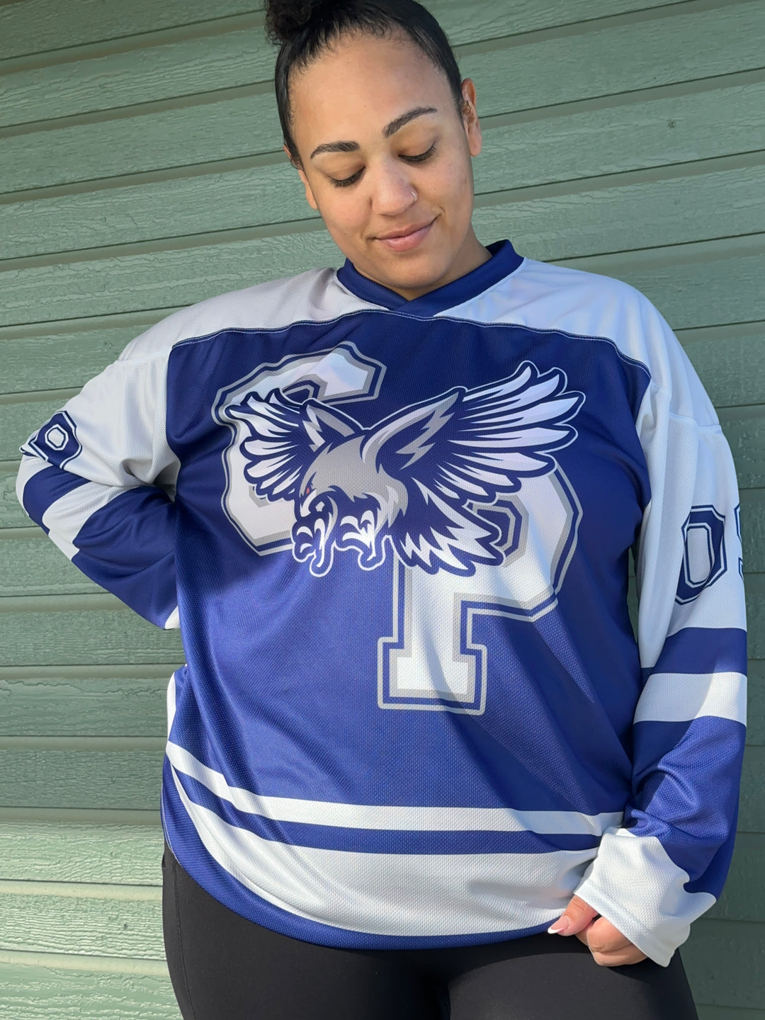 a man in a blue and white jersey holding a black motorcycle