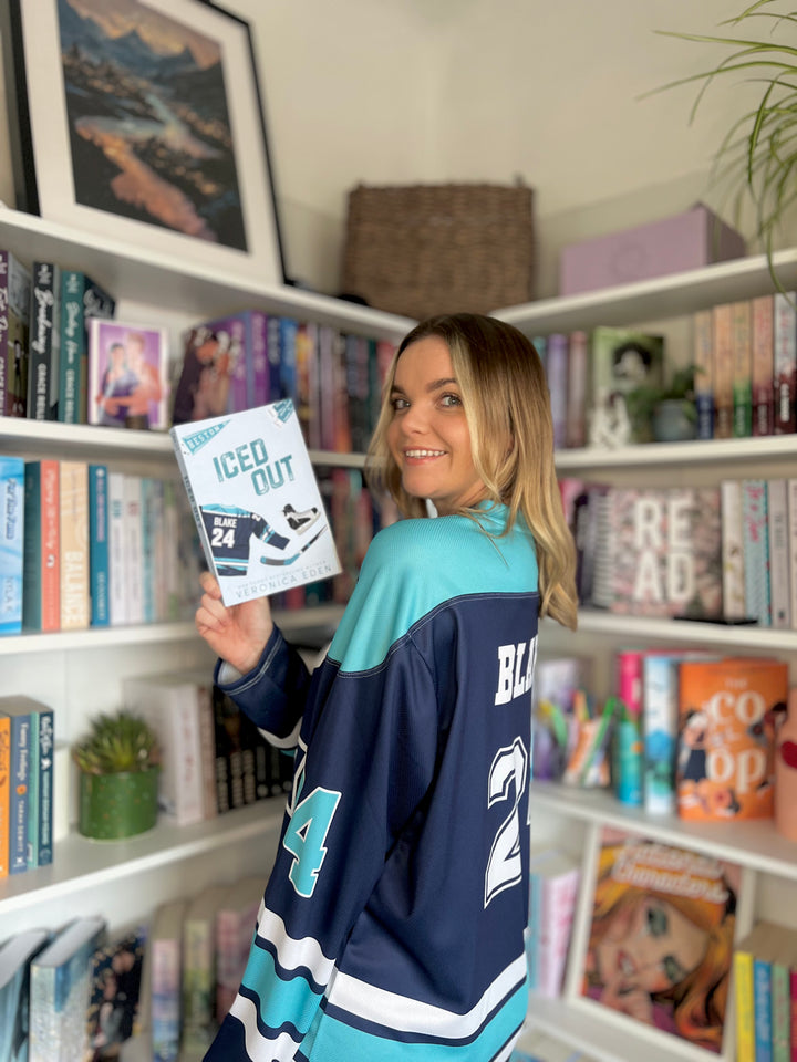 a woman in a hockey jersey holding a book