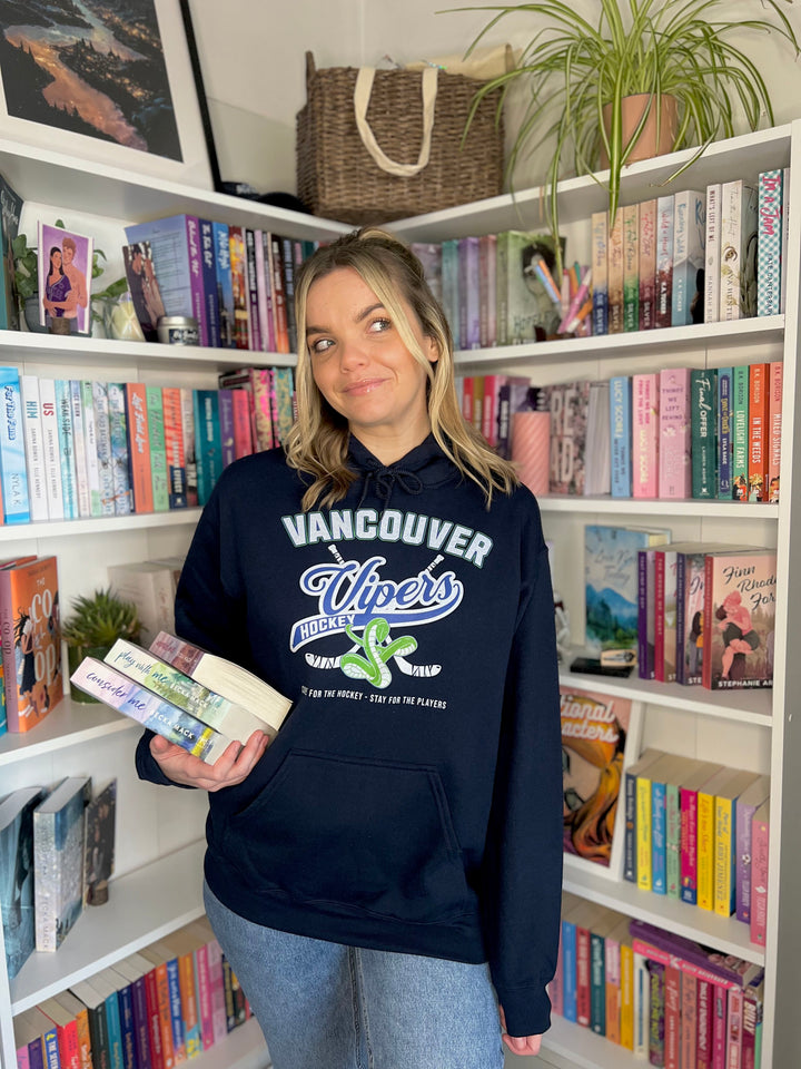 a woman standing in front of a bookshelf holding a book