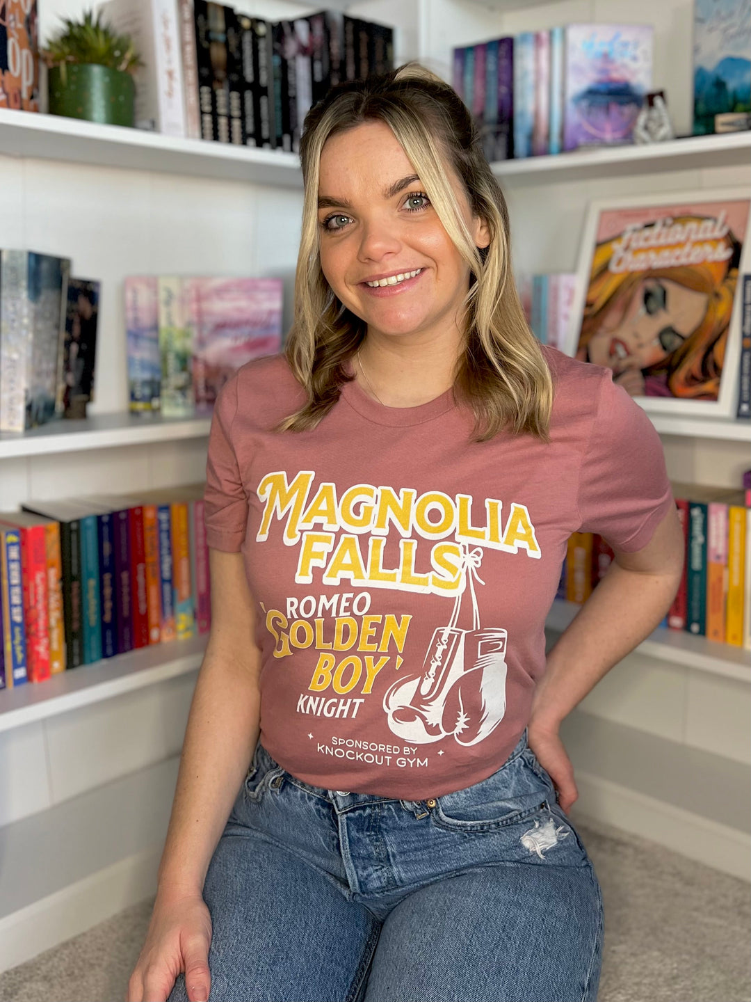 a woman sitting on the floor in front of a bookshelf