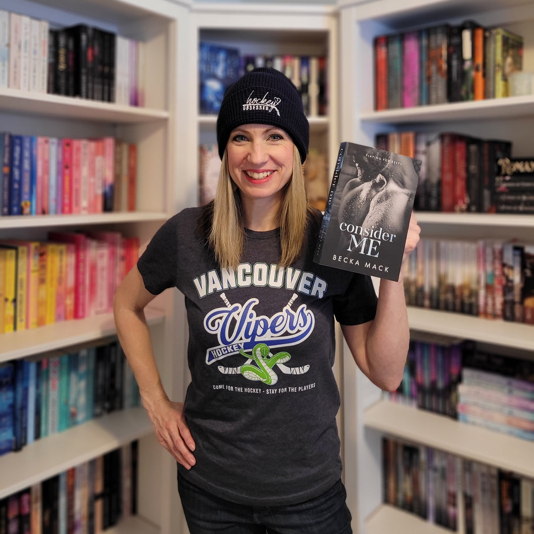 a woman holding a book in front of a bookshelf