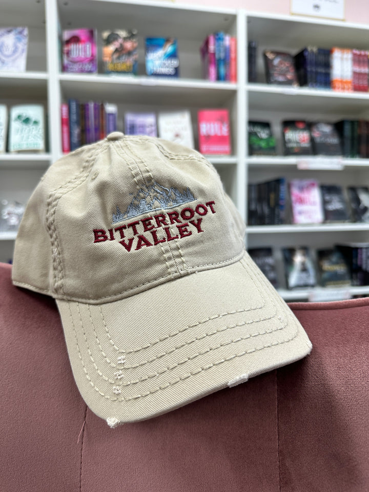 a baseball cap on a person's shoulder in front of a bookcase