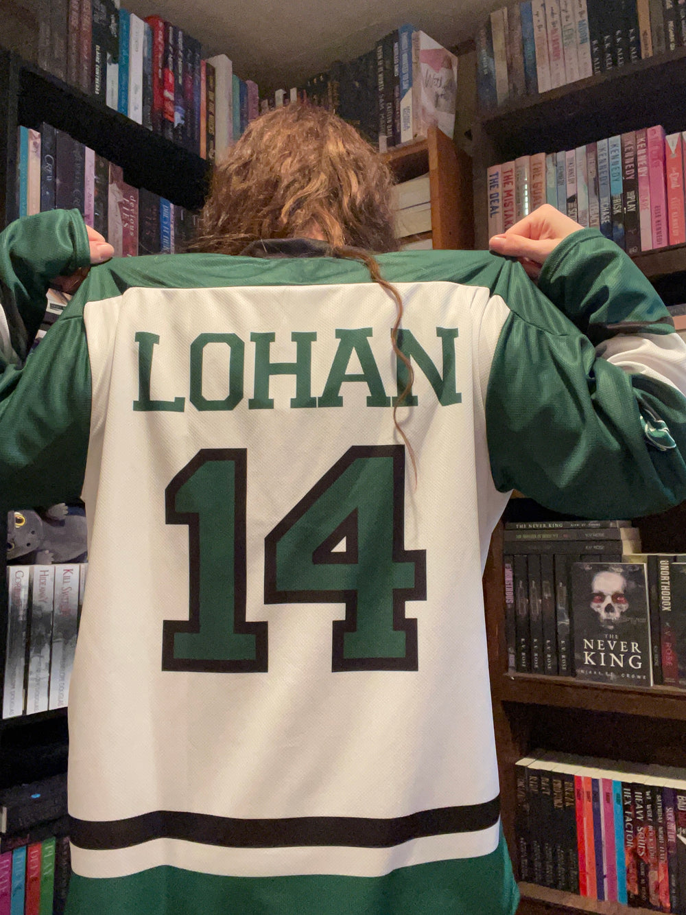 a person in a green and white jacket holding a sign