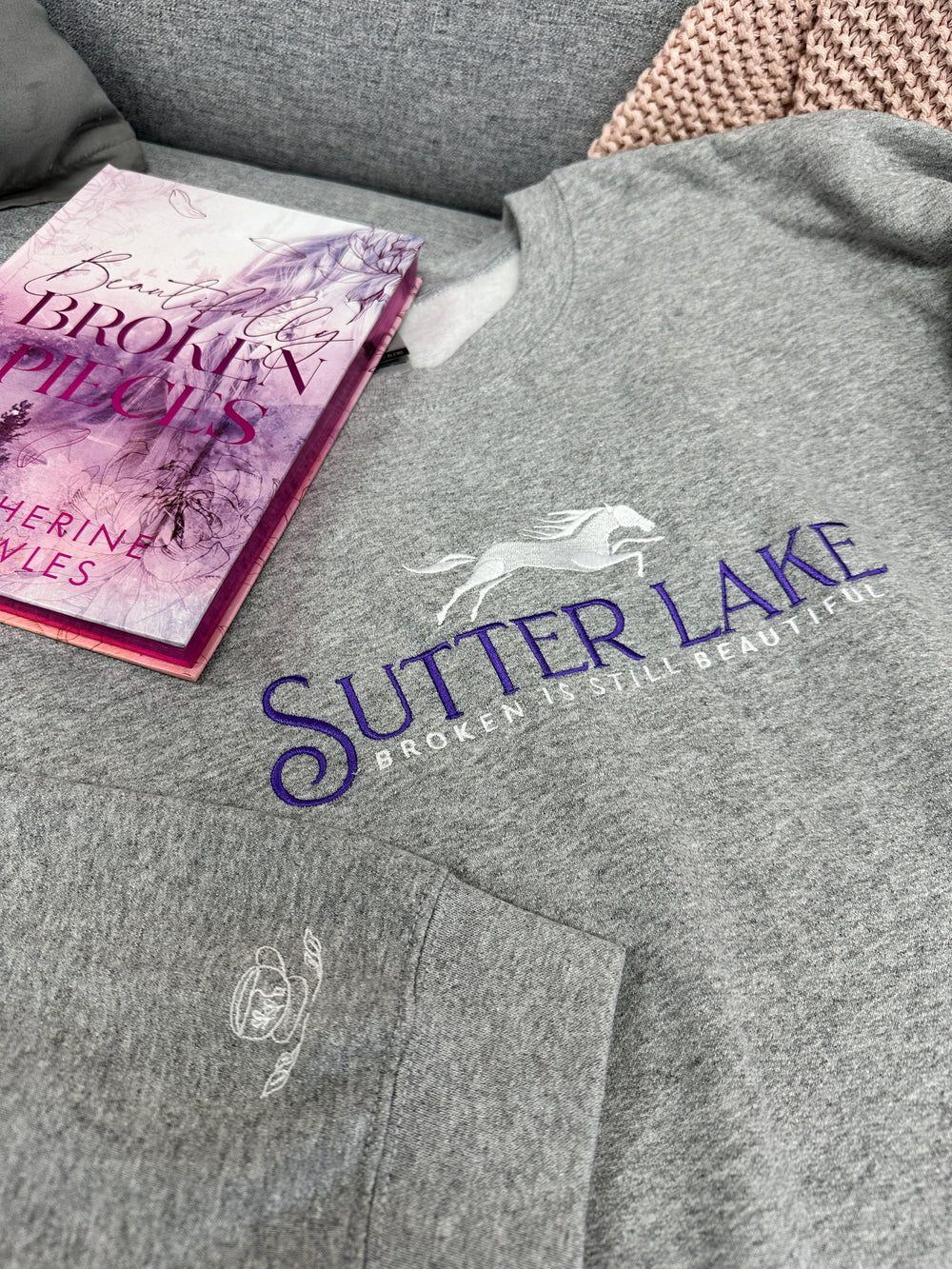 a person wearing a grey shirt and a pink book