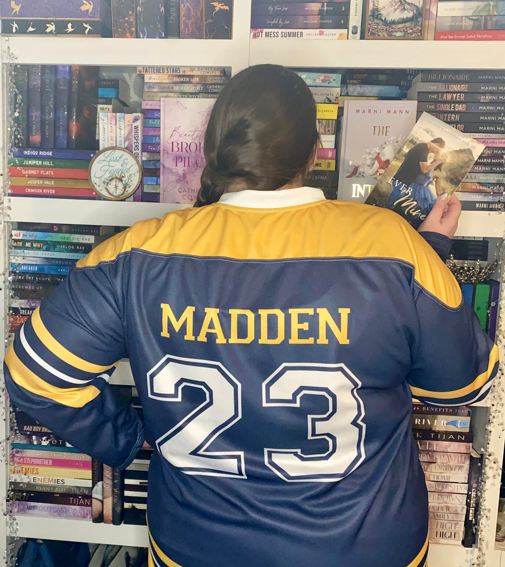 a woman in a blue and yellow jacket reading a book