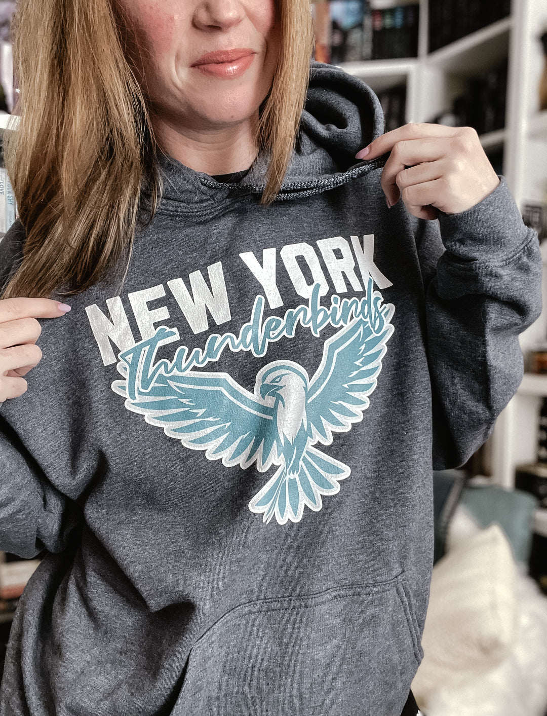 a woman is holding onto a new york sweatshirt