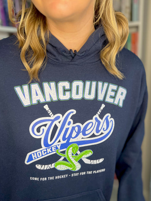 a woman wearing a vancouver uppers hoodie in front of a bookshelf