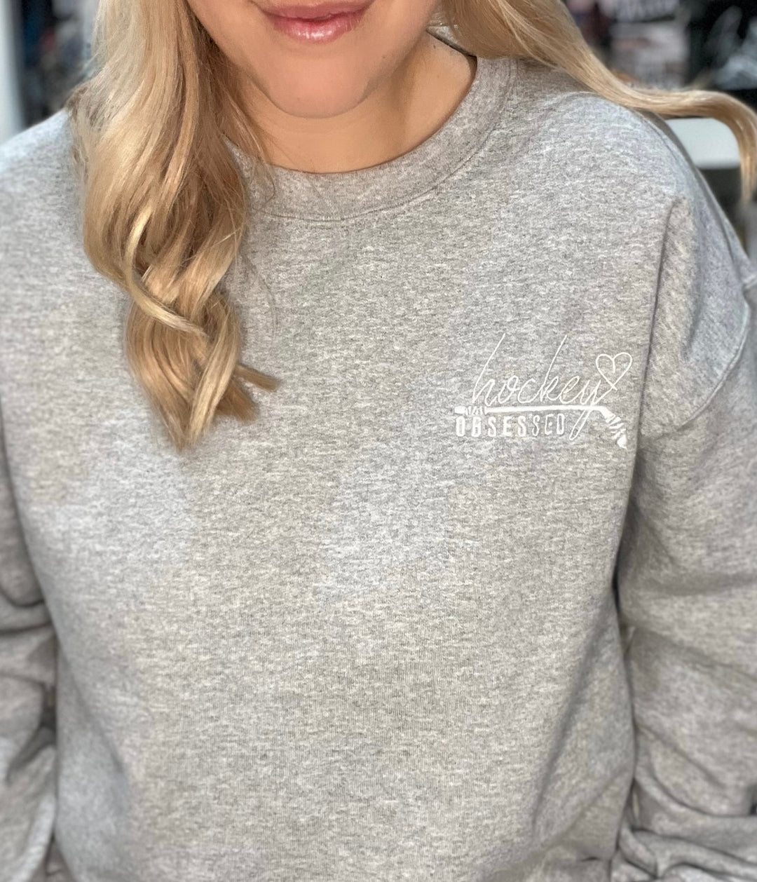 a woman wearing a gray sweatshirt and a pair of glasses