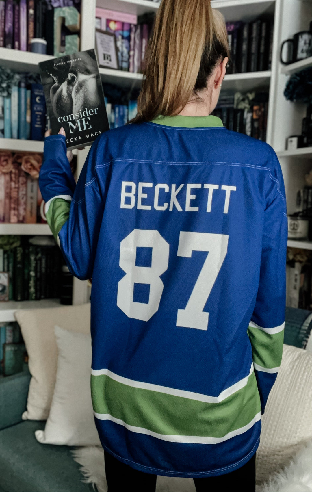 a woman in a hockey jersey reading a book