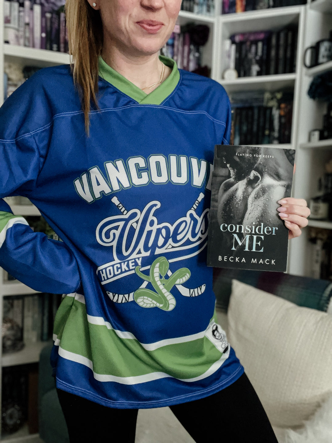 a woman in a hockey jersey holding a book