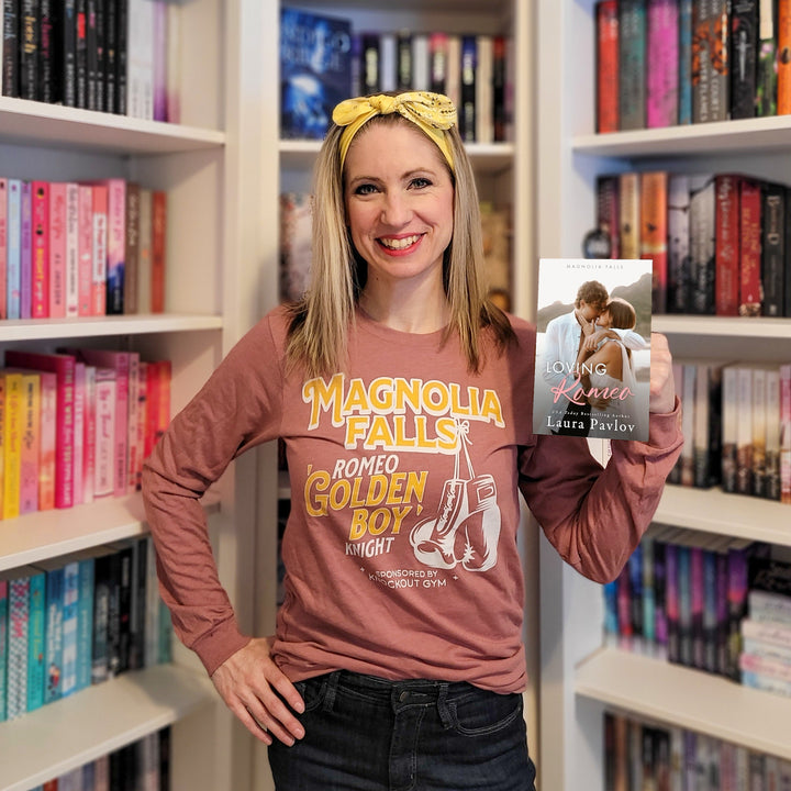 a woman holding up a book in front of a bookshelf