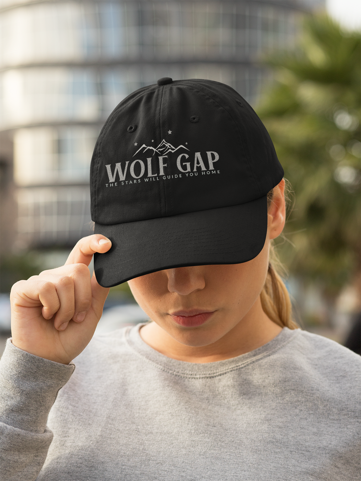 a woman wearing a black hat with the word wolf gap on it