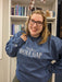 a woman wearing a blue sweatshirt with the word wolf gap on it