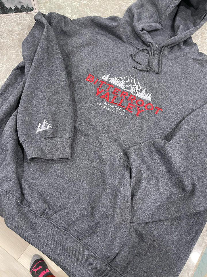 a grey hoodie with a red and white logo on it