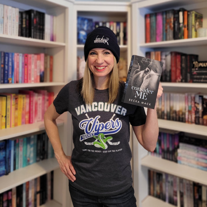 a woman holding a book in front of a bookshelf