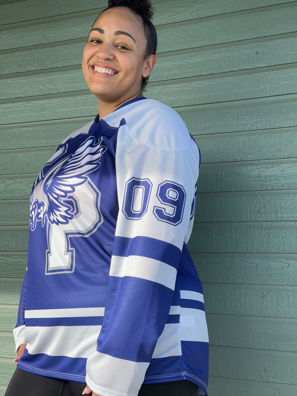 a woman in a blue and white uniform holding a baseball glove
